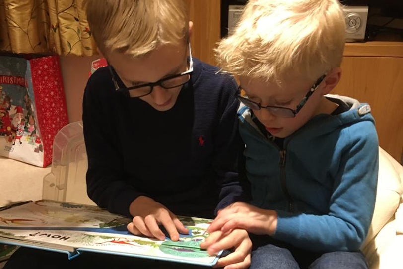 Two boys reading a book